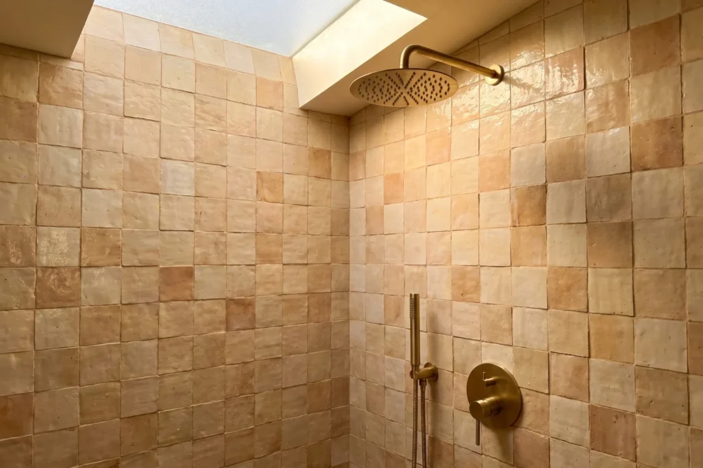 Shower wall with zellige-style tan tiles