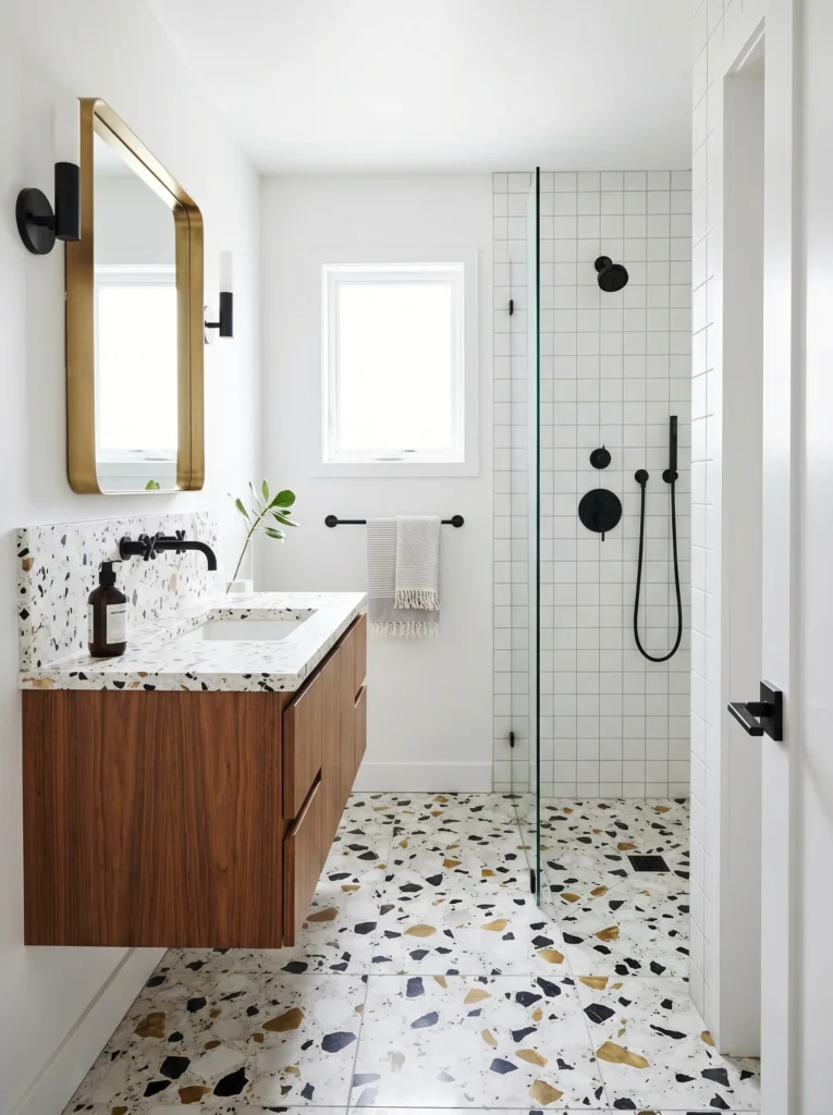 Modern bathroom with colorful terrazzo floor, walnut vanity, terrazzo counter, and matte black fixtures.