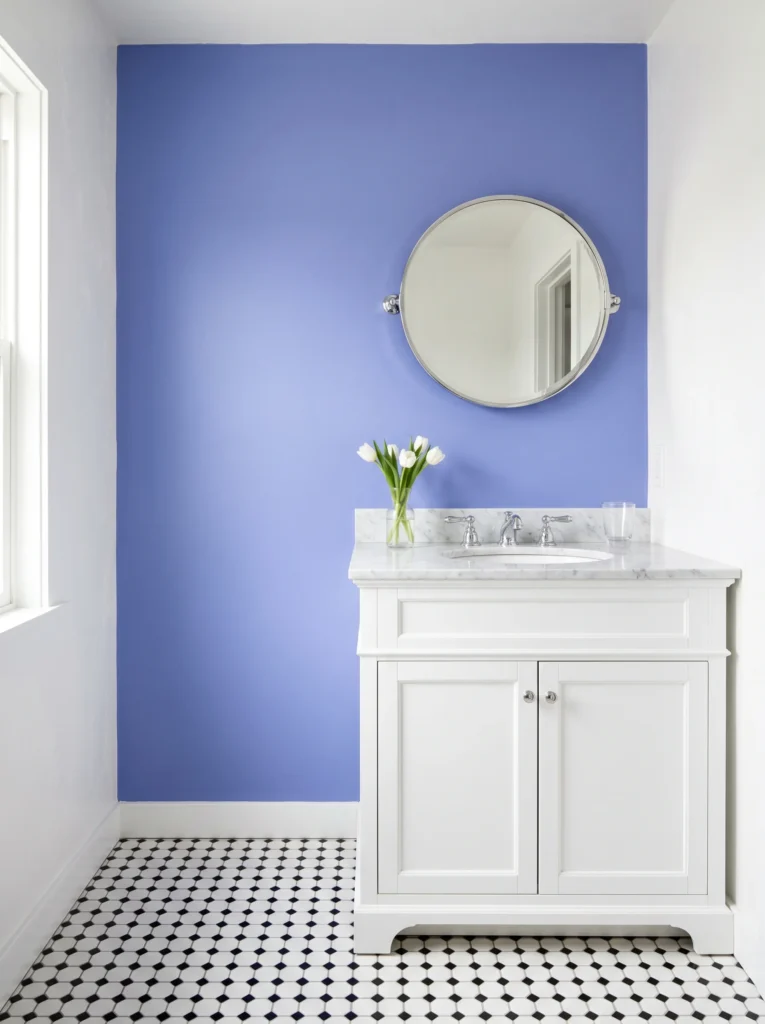 Classic black and white bathroom with a single periwinkle blue-violet accent wall behind a white vanity, black and white hexagon floor tile, marble sink top, chrome fixtures, and white tulips