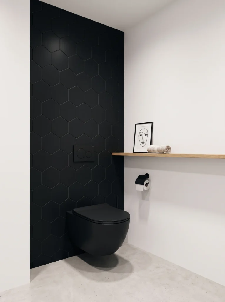 Black hexagon tile feature wall behind a wall-hung black toilet with an oak floating shelf
