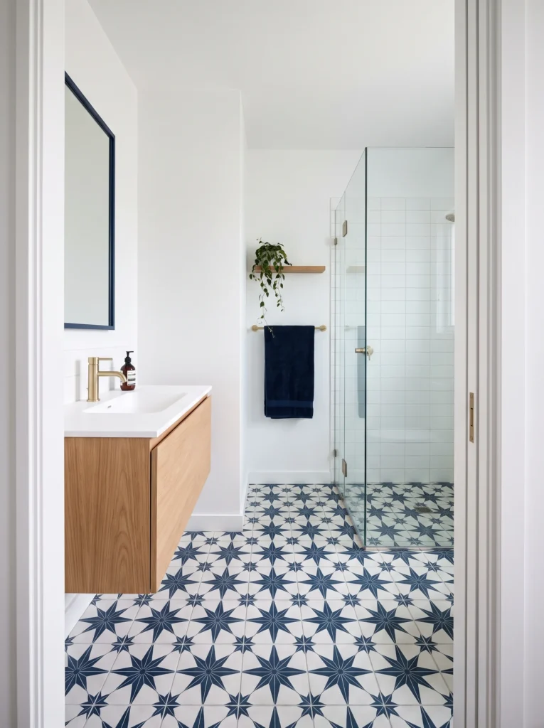 navy and white star patterned encaustic floor tile with white walls, oak floating vanity and glass shower