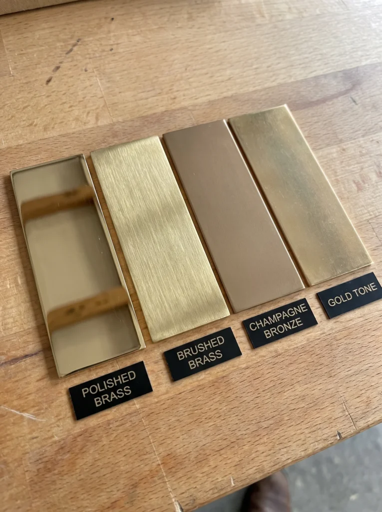 four gold metal finish samples labeled polished brass, brushed brass, champagne bronze, and gold tone