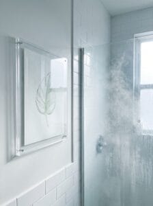 Clear acrylic standoff frame mounted beside a steamy shower screen