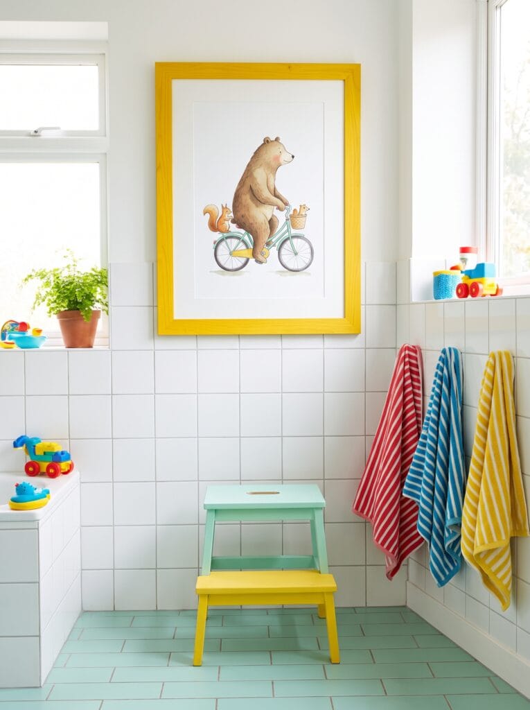 Colorful animal print in a yellow frame in a bright kids bathroom