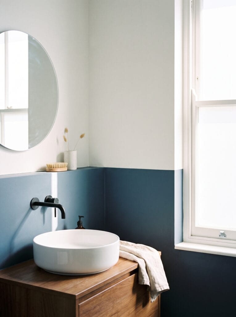 Bathroom with the lower wall painted deep blue and chalk white above