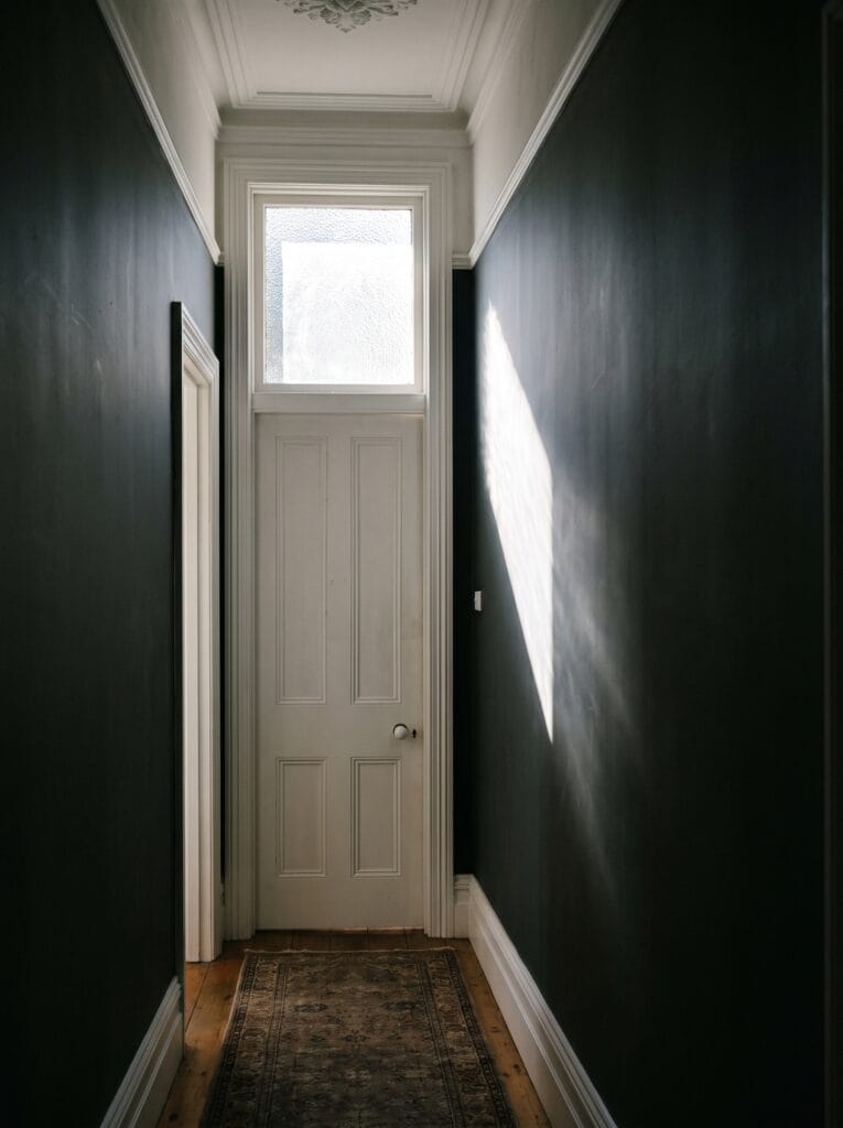 White panelled bathroom door with a glazed transom window above it