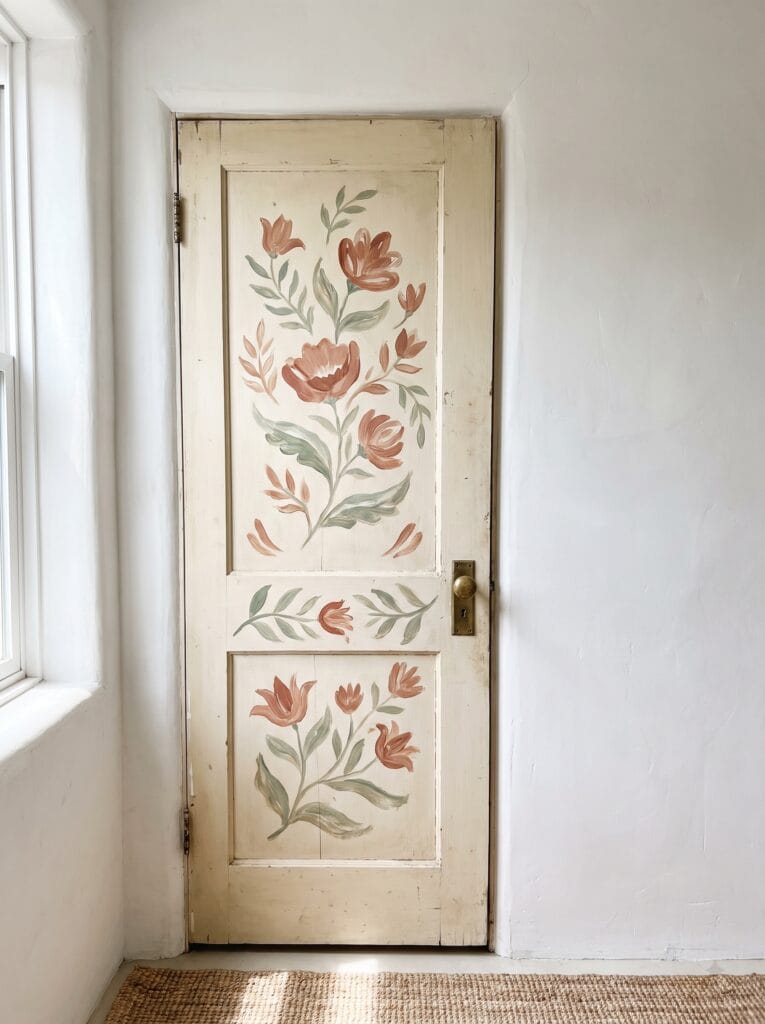 Cream bathroom door with a hand painted floral design across its panels