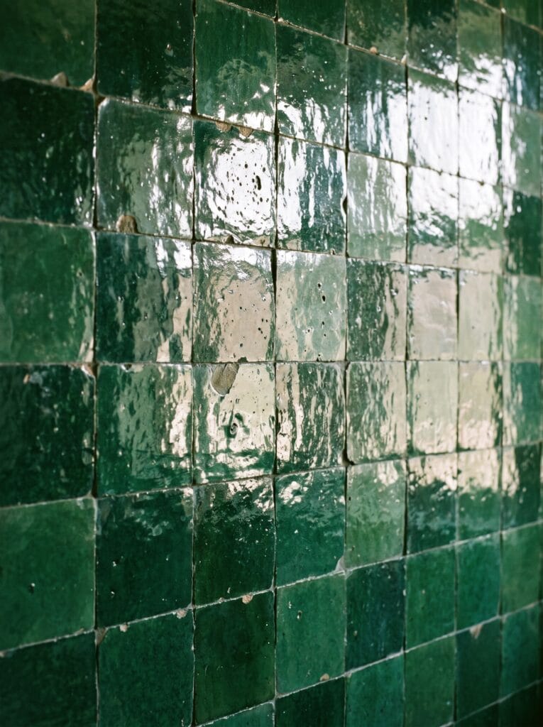 Close view of handmade green zellige tile with pooled irregular glaze