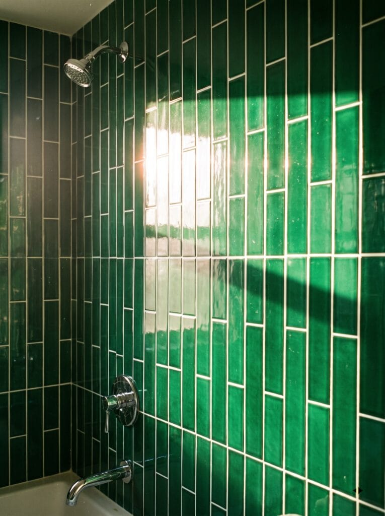 Emerald green bathroom tile stacked vertically in direct afternoon sun