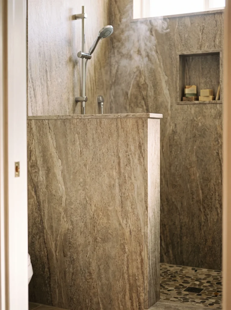 Stone look wall panels on a walk-in shower half wall
