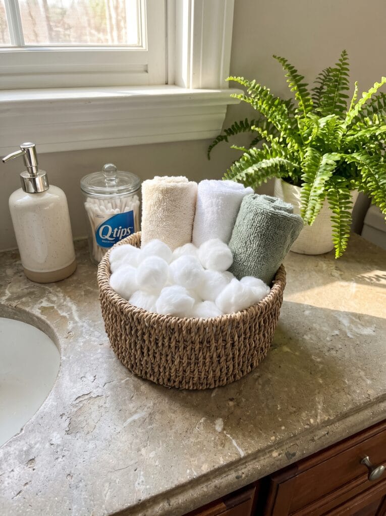 woven basket hanging from a hook on the shower wall holding a bar of soap and loofah